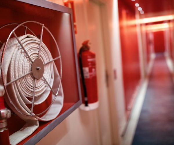 Fire extinguisher and fire hose reel in hotel corridor
